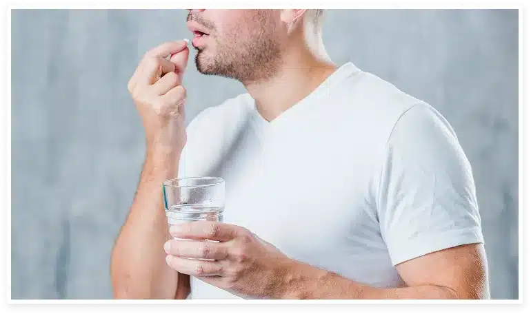 Hombre tomandose una pastilla de finasteride